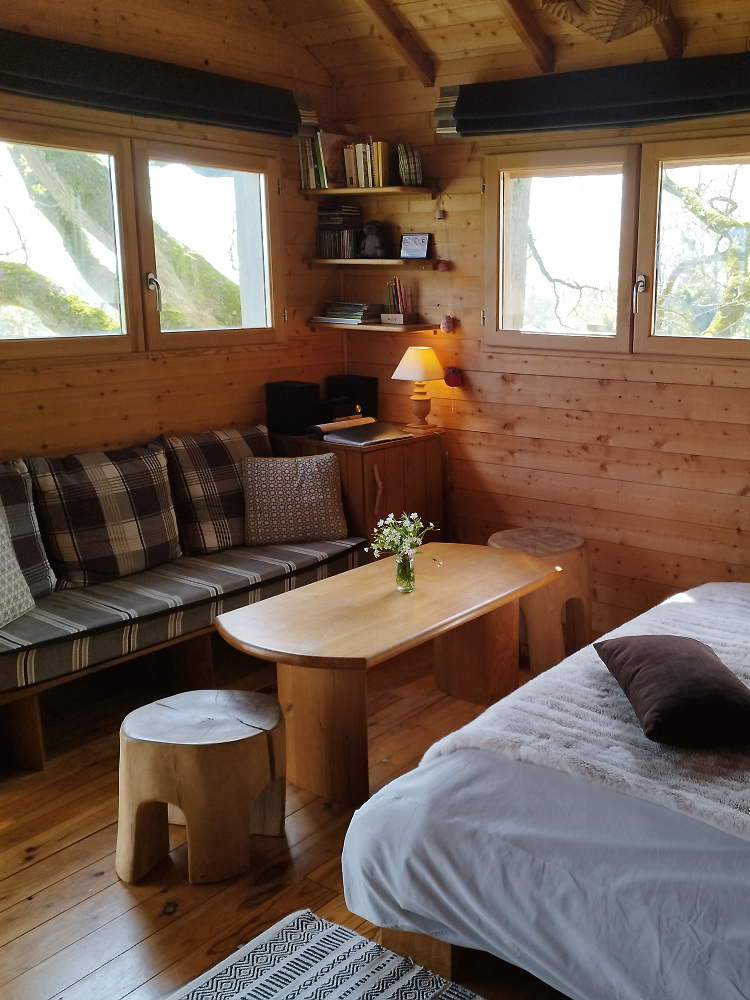 chambre et coin salon de la cabane des chênes dans les arbres
