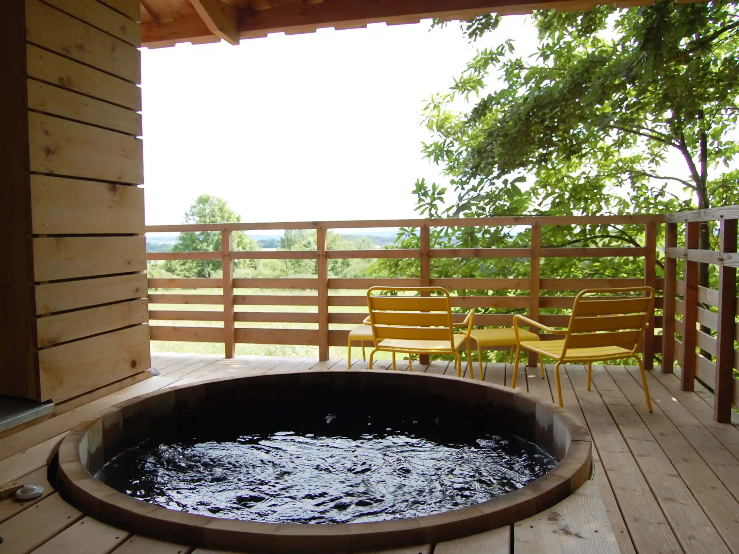 Bain nordique privatif sur la terrasse de la Cabane Spa avec vue sur les prairies du Perche